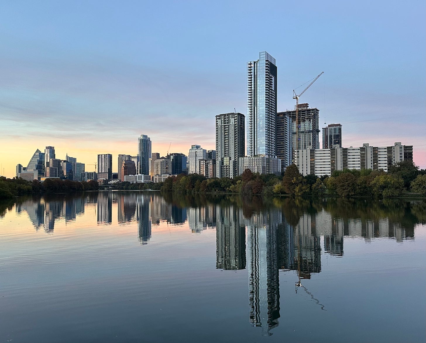 The skyline of Austin, Texas reflects in Lady Bird Lake at sunet.