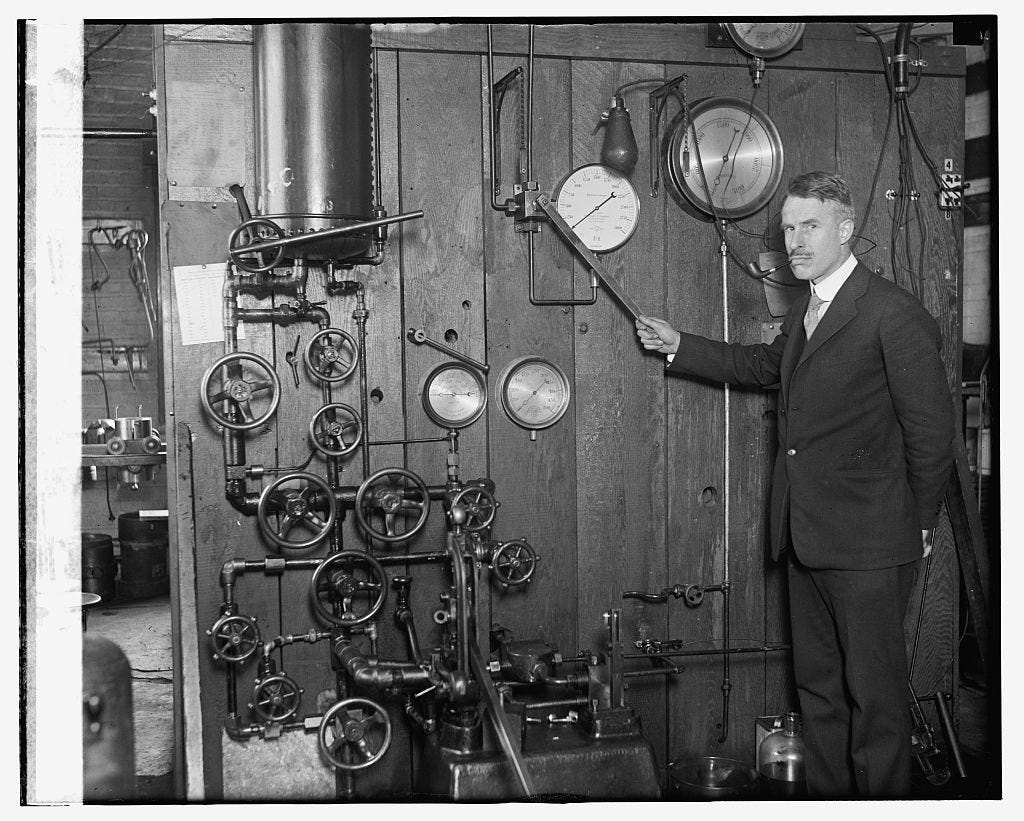 A 1920s photo of a man in front of a machine that just screams "science"a 