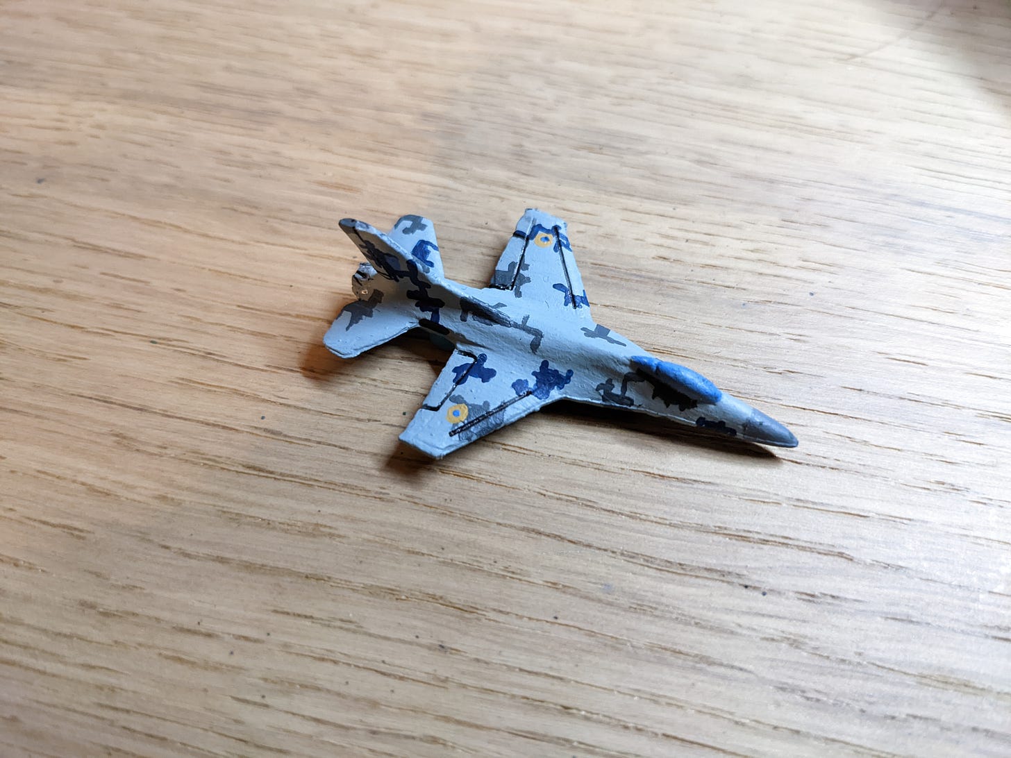 A 6 mm scale model of an F-16 fighter painted in grey and light grey ukrainian digital camo