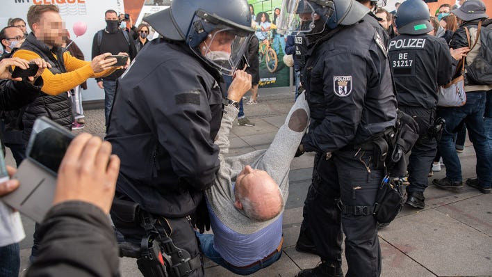 Polizisten tragen einen Teilnehmer der Demonstration gegen die Corona-Auflagen auf dem Alexanderplatz weg (Quelle: dpa/Paul Zinken)