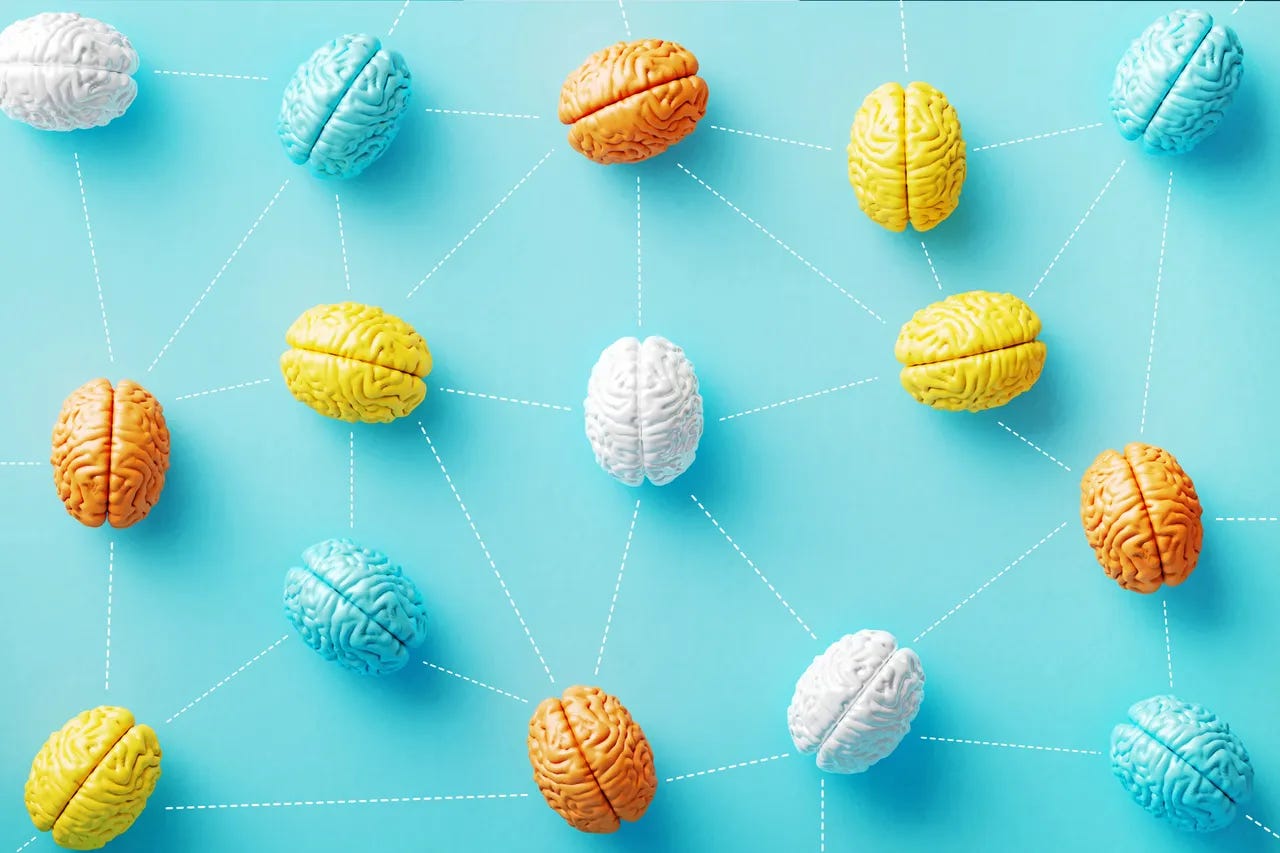 Varios cerebros coloridos ligados por linhas pontilhadas em um fundo azul