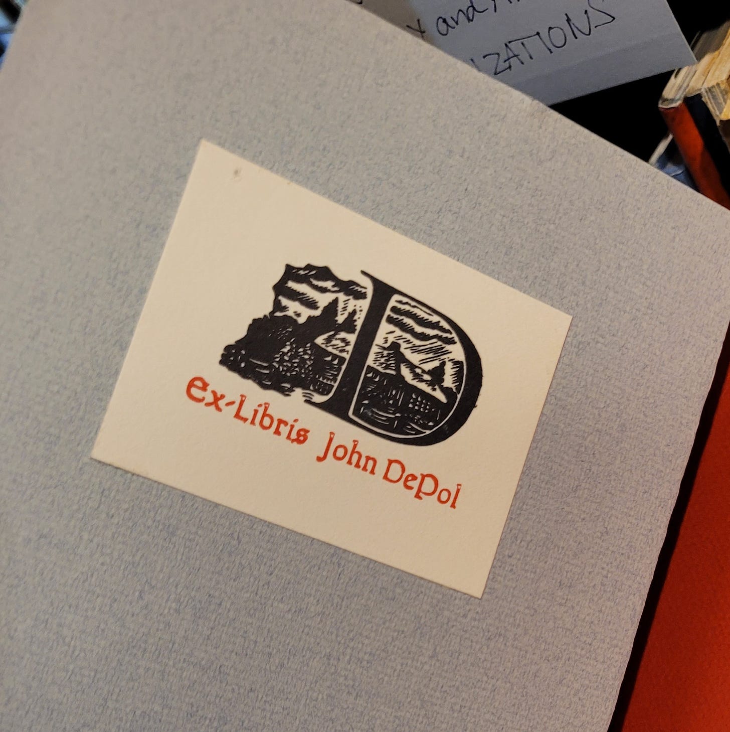 photo of a book plate with text "ex libris jon de pol" and a woodcut of a letter D with illustration of a house