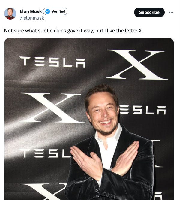Elon Musk tweet: Not sure what gave it away but I like the letter X. Image: Elon Musk making an X with his arms in front of a step and repeat that says Tesla X
