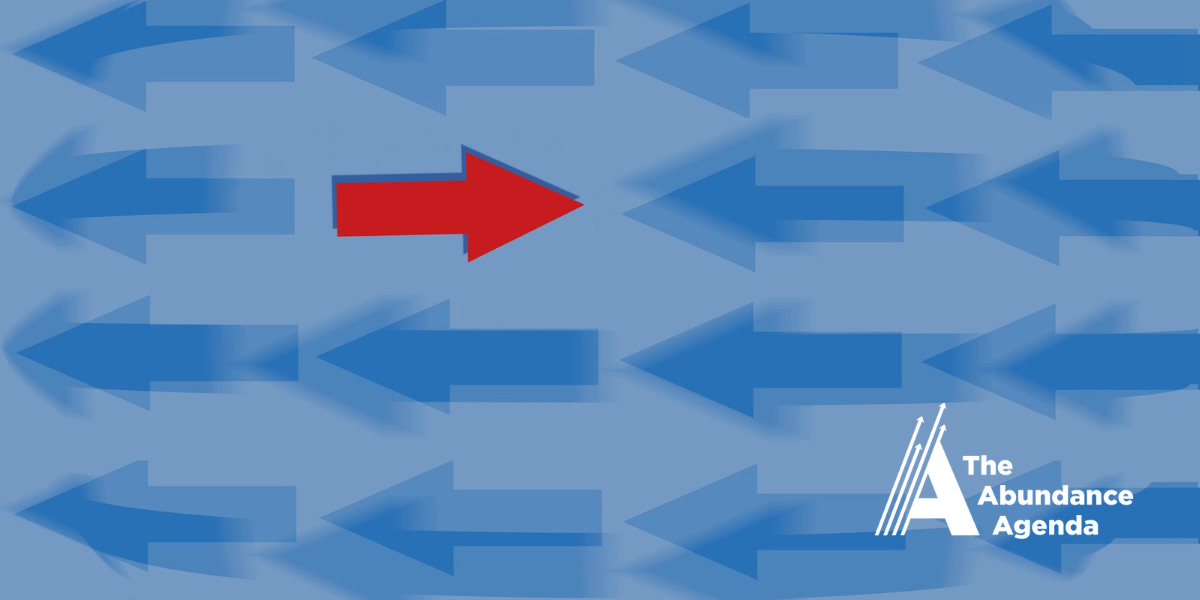 A red arrow points in a different direction from a host of blue arrows.