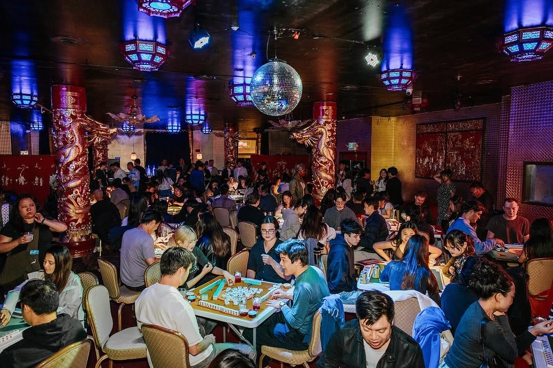 young people playing mahjong in a dart room under a disco ball
