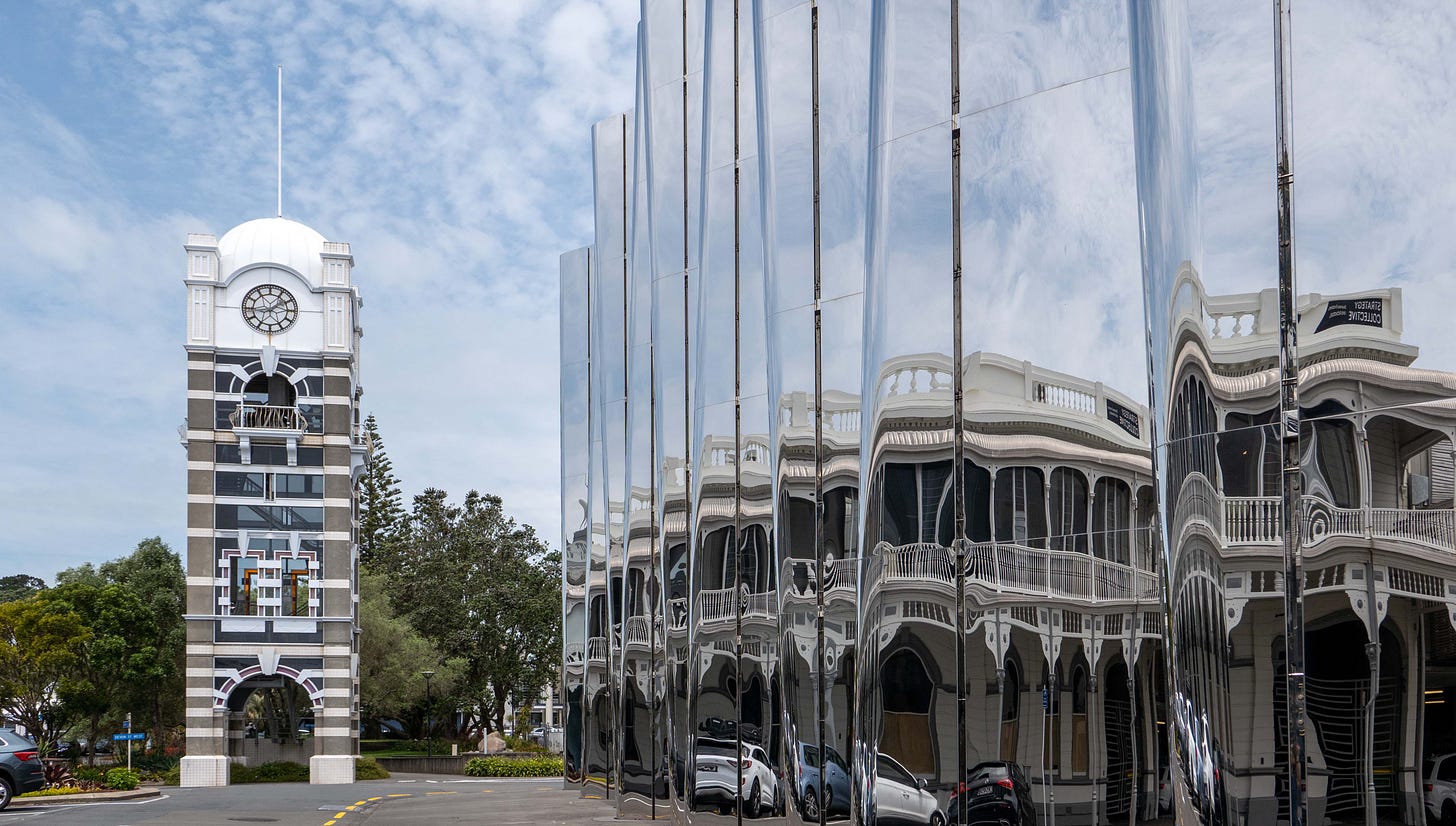 Historic buildings reflected in the modern steel frontage of the Govett-Brewster Art Gallery