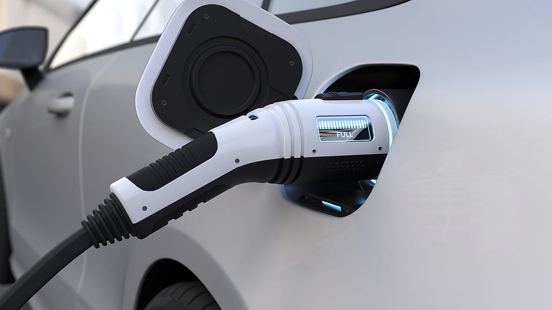An electric car charging showing a fully charged status whilst plugged into the car