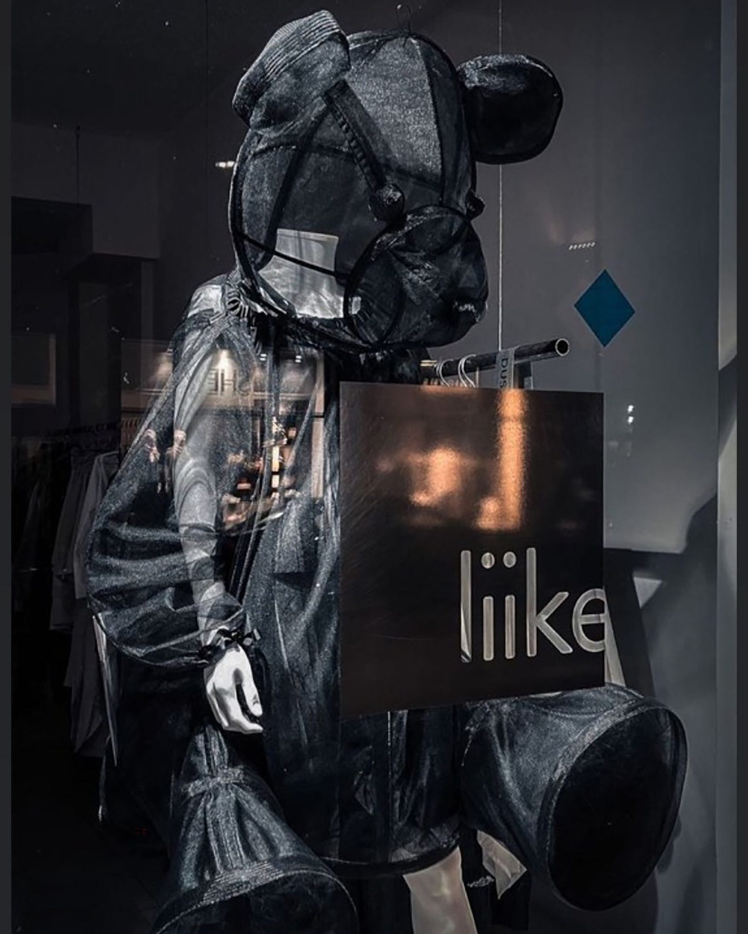 a mannequin wearing a transparent black teddy bear costume in a shop window