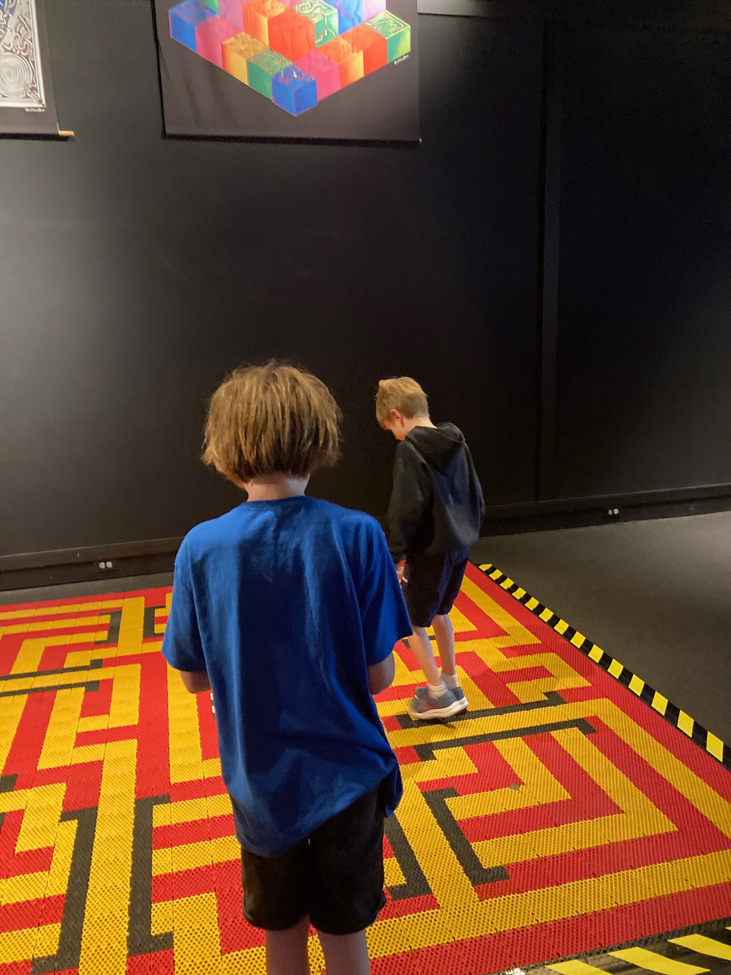 Photo of my kids (two white boys in t-shirts) doing a floor maze at the Museum of Science in Boston