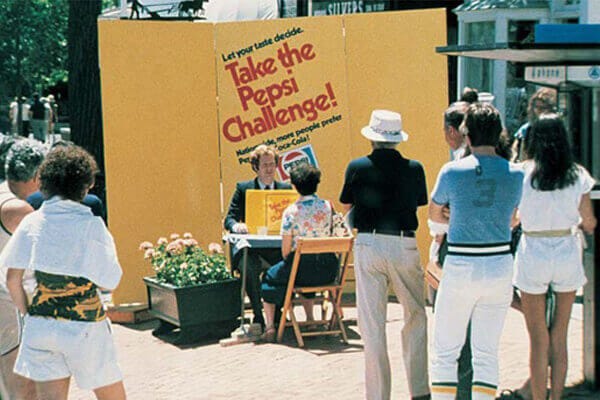 People in the 1980's stand around watching the Pepsi challenge