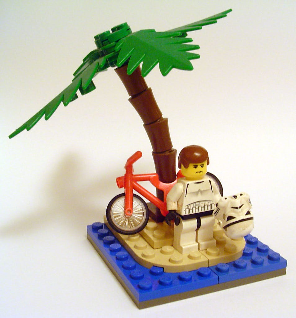 A minifig person with a bicycle on a tiny desert island. "Annoying things to be stranded with on a desert island # 1:" by minifig is licensed under CC BY-NC-SA 2.0. 