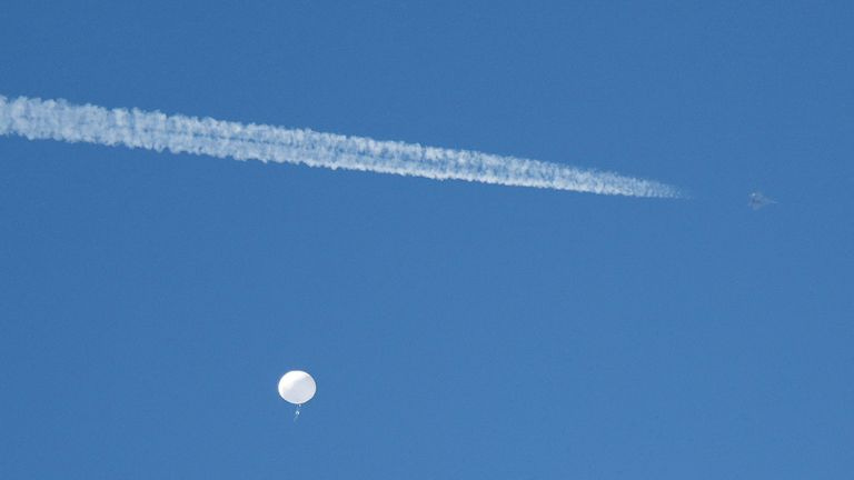 A jet flies by a suspected Chinese spy balloon as it floats off the coast of South Carolina