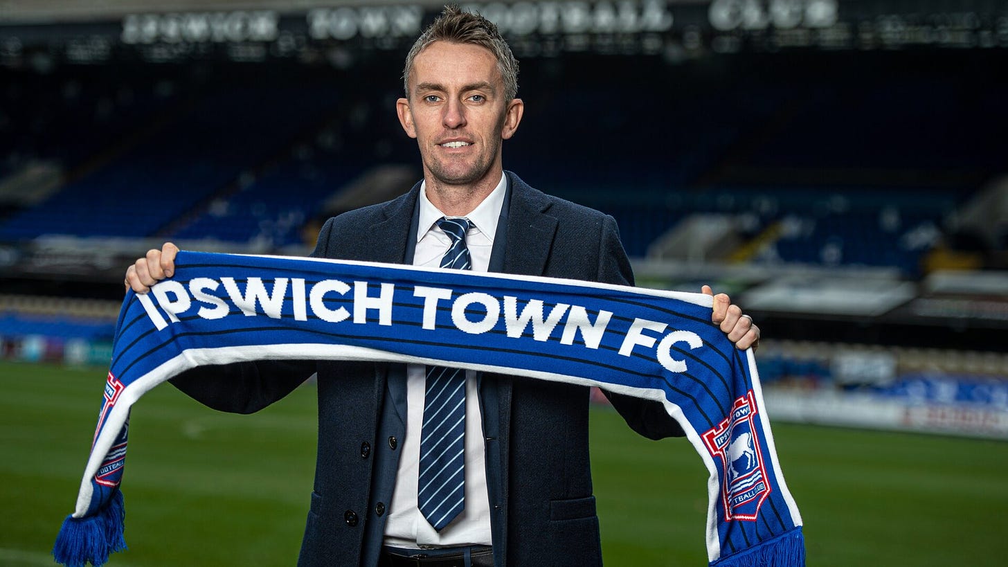 Kieran McKenna in suit and tie, poses for photos on the pitch after being appointed Ipswich manager in December 2021#