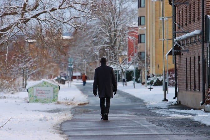 Person walking along a path with snow either side