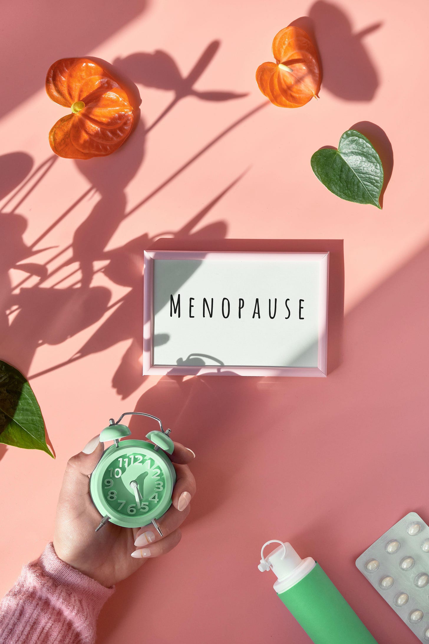 A light box on a pink table that has the word Menopause written on it 