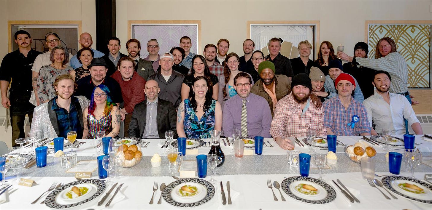 A group gathered in front of table set for a celebration meal