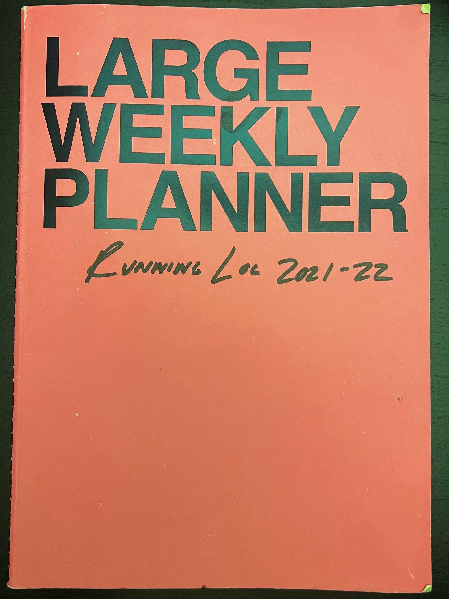 A photo of a weekly planner with "Running Log 2021-22" scribbled on it.