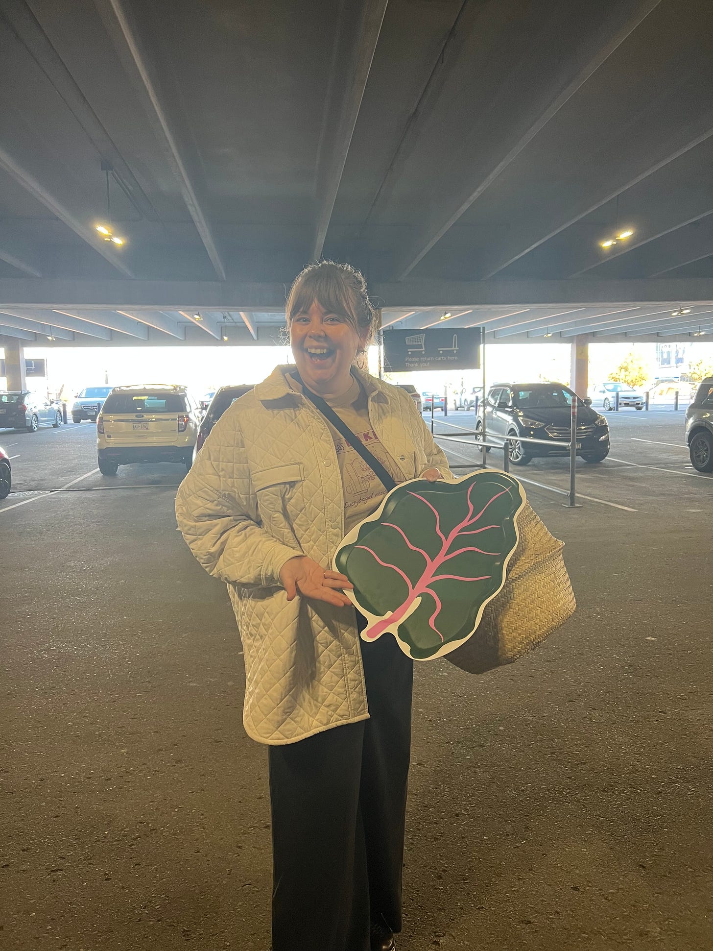 photo of Melissa holding a rhubarb shaped tray in the IKEA parking lot