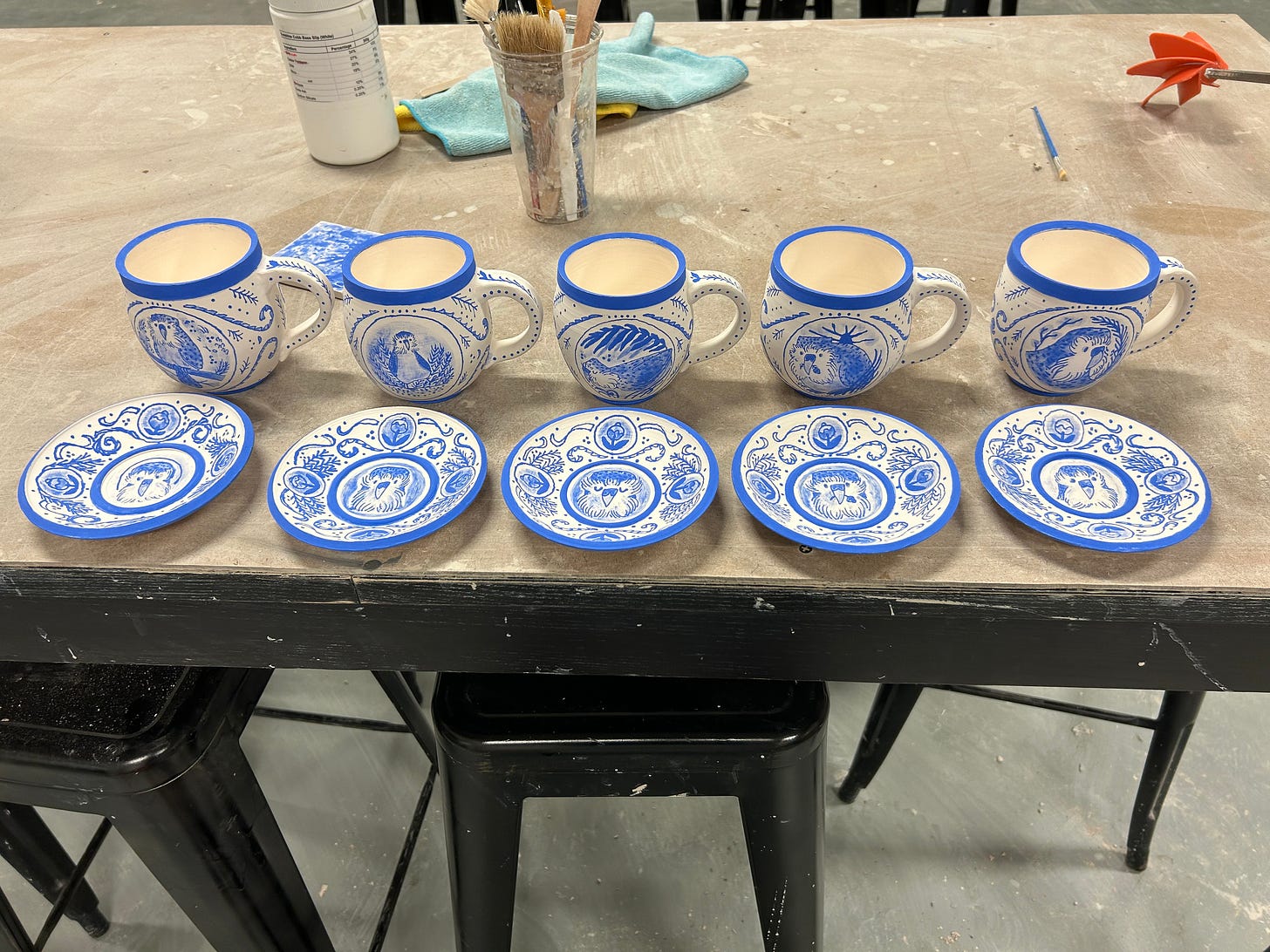 all 5 kakapo mug and saucer sets at the ceramic studio by Kayla Stark and Brad Henderson