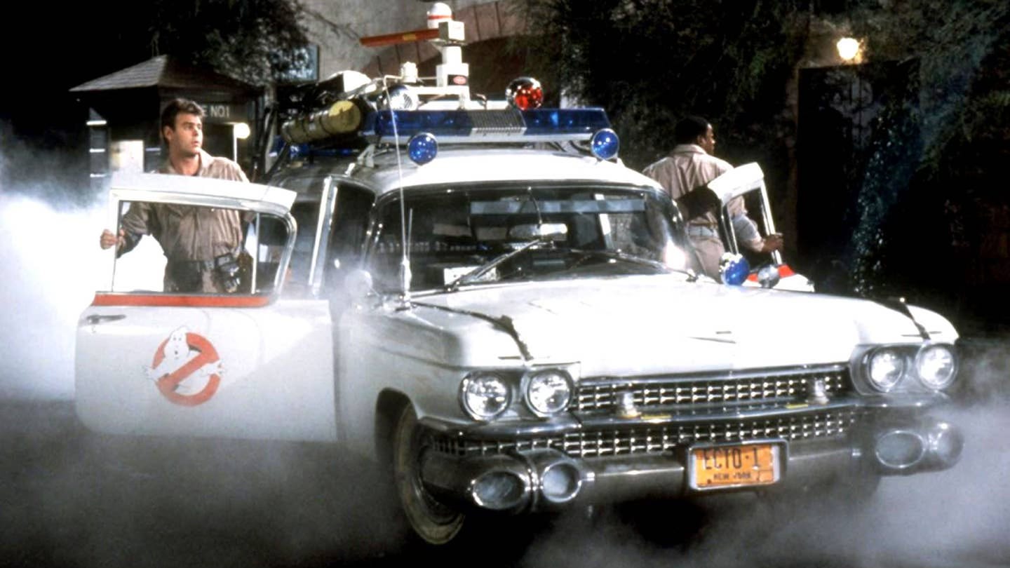 Ray Stantz and Winston Zedmore step out of the Ecto-1 into the foggy night in Ghostbusters.