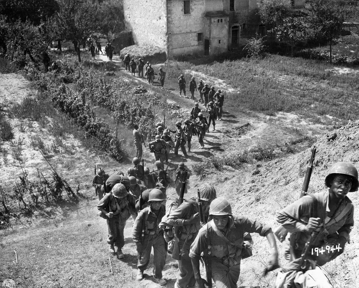 Advancing through the hill country of Cacina, Italy, soldiers of Company I, 3rd Battalion, 370th Infantry Regiment, 92nd Division move toward the front lines during the Italian campaign.