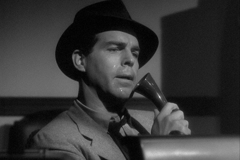 Fred MacMurray as Walter Neff in Billy Wilder's film 'Double Indemnity'. He's talking into a Dictaphone, obviously in pain, wearing his fedora at an angle