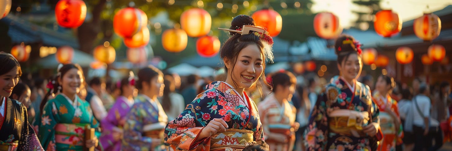 A woman dressed in a colorful traditional kimono smiles warmly, surrounded by people wearing similar attire at an outdoor cultural event. The scene is illuminated by vibrant paper lanterns and the soft, golden glow of sunset.