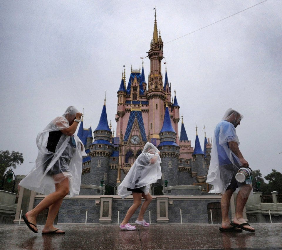 Guests weather early rainfall from Hurricane Milton at the Magic Kingdom at Walt Disney World on Wednesday