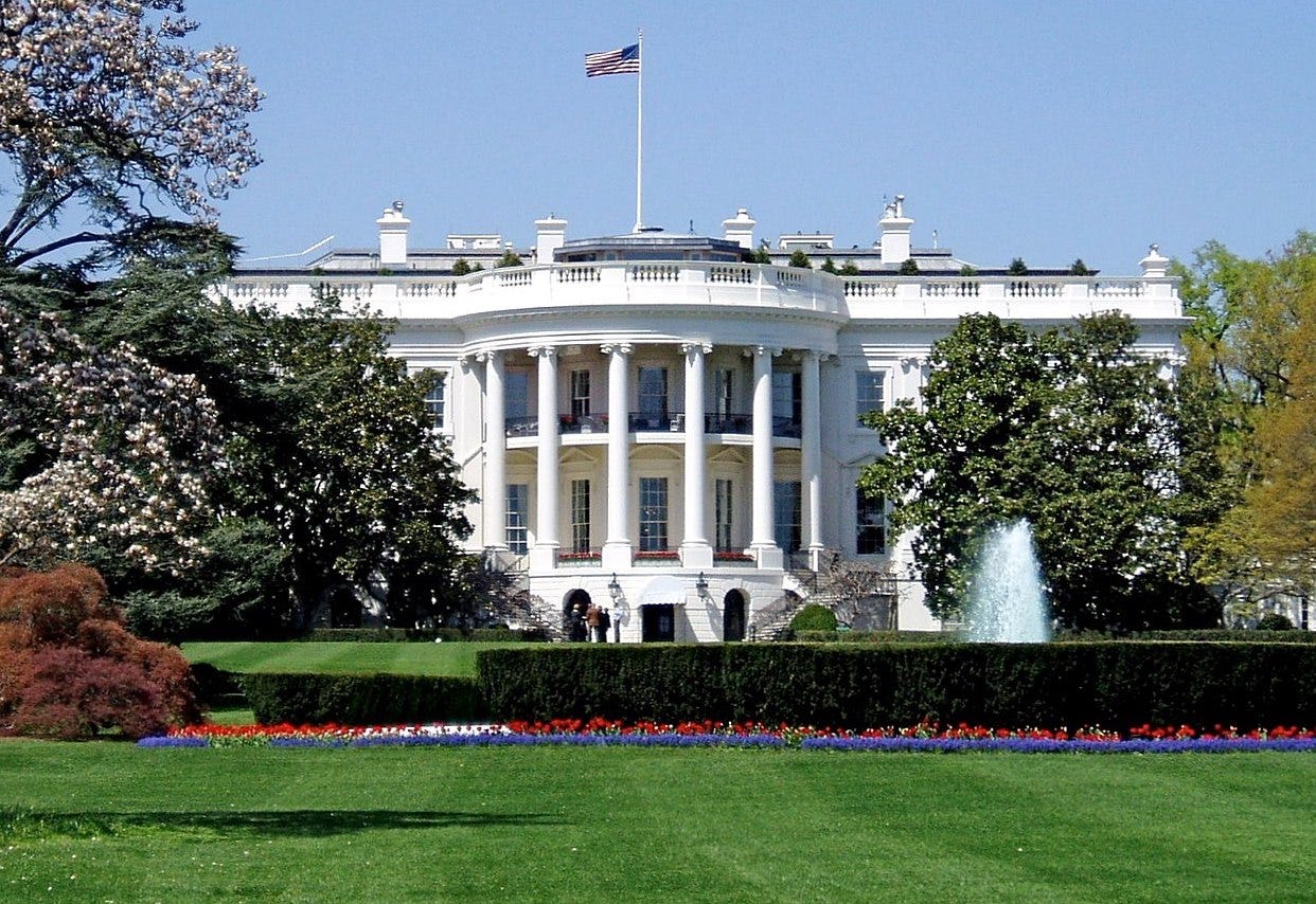 The south facade of the White House on a sunny day with flowers blooming.