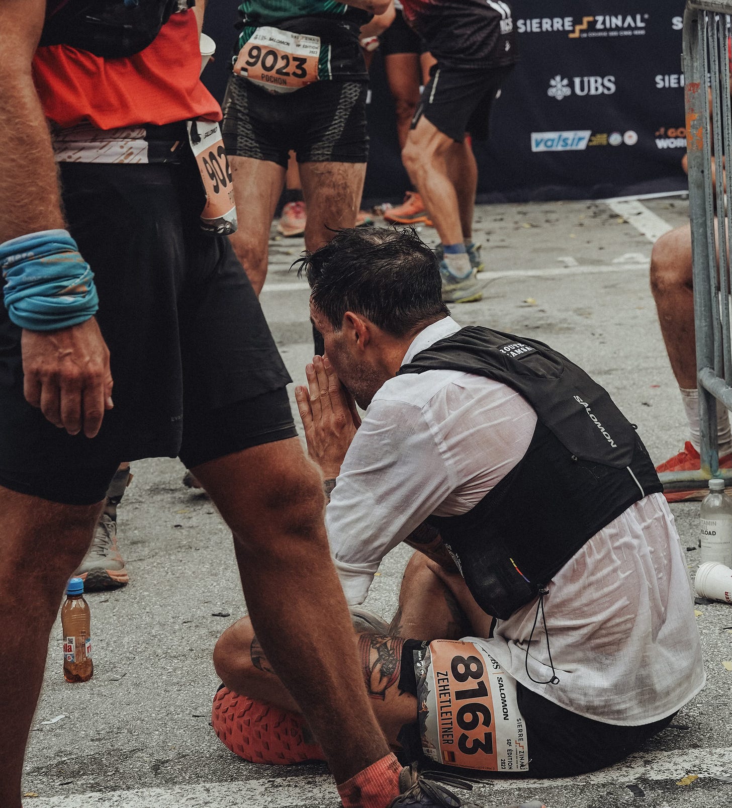 The author sitting on the ground of the finish of Sierre-Zinal 2023