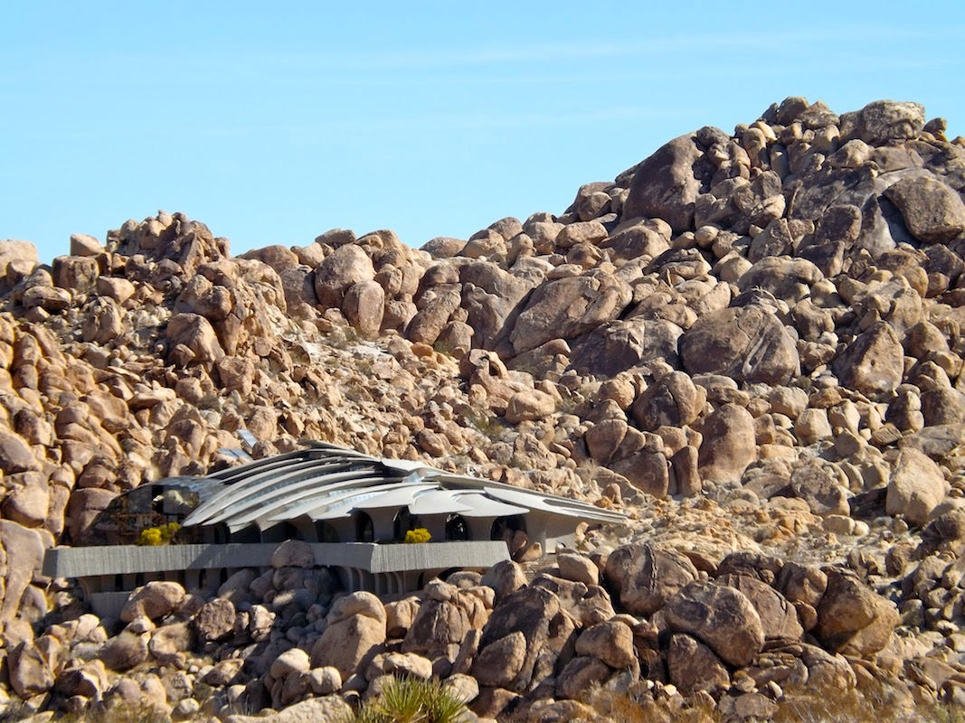 Photo by Sherry Killam Arts of a fantastic house built into a giant mound of boulders.