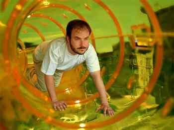 A man crawls through a giant hamster tunnel
