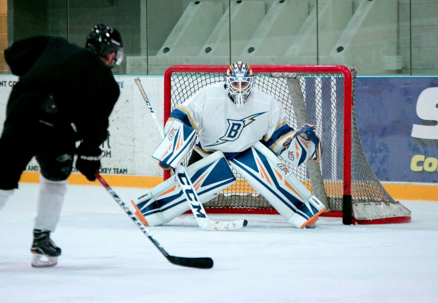 male ice hockey keeper defending the goal on the ice ring