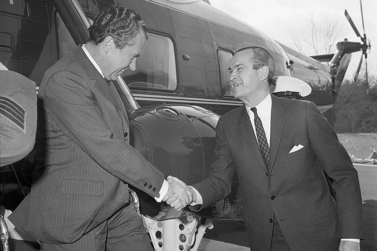 Richard Nixon steps off a helicopter, shaking hands with CIA director Richard Helms.