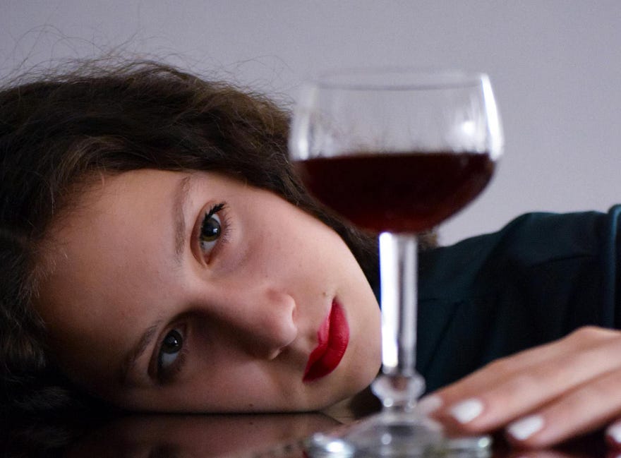 woman contemplating a glass of wine