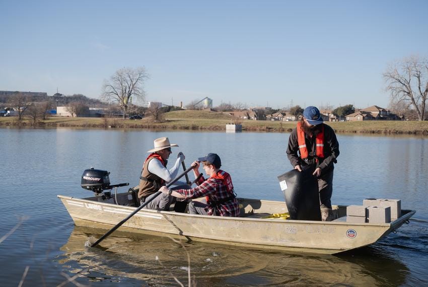 DALLAS, TX - JANUARY 30, 2024: From left to right, Employees of the U.S. Environmental Protection Agency (EPA), Robert Cook, 54, environmental scientist, Nicholas Scott, 30, physical scientist, and Jamie Morgan, 35, aquatic biologist at Jacobs Solutions, prepare to set up gillnets at Fish Trap Lake Park in Dallas, Texas on Tuesday, Jan. 30, 2024. The city of Dallas and local community leaders partnered with the EPA on the Cumulative Impacts Assessment Pilots Project, which focuses on the cumulative impacts from concrete batch plants. CREDIT: Desiree Rios for The Texas Tribune
