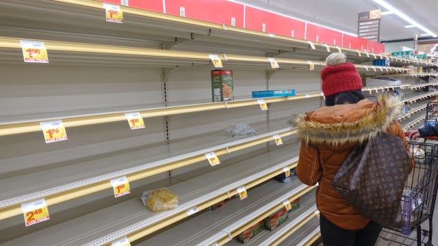 Female shopper looks at empty supermarket shelf