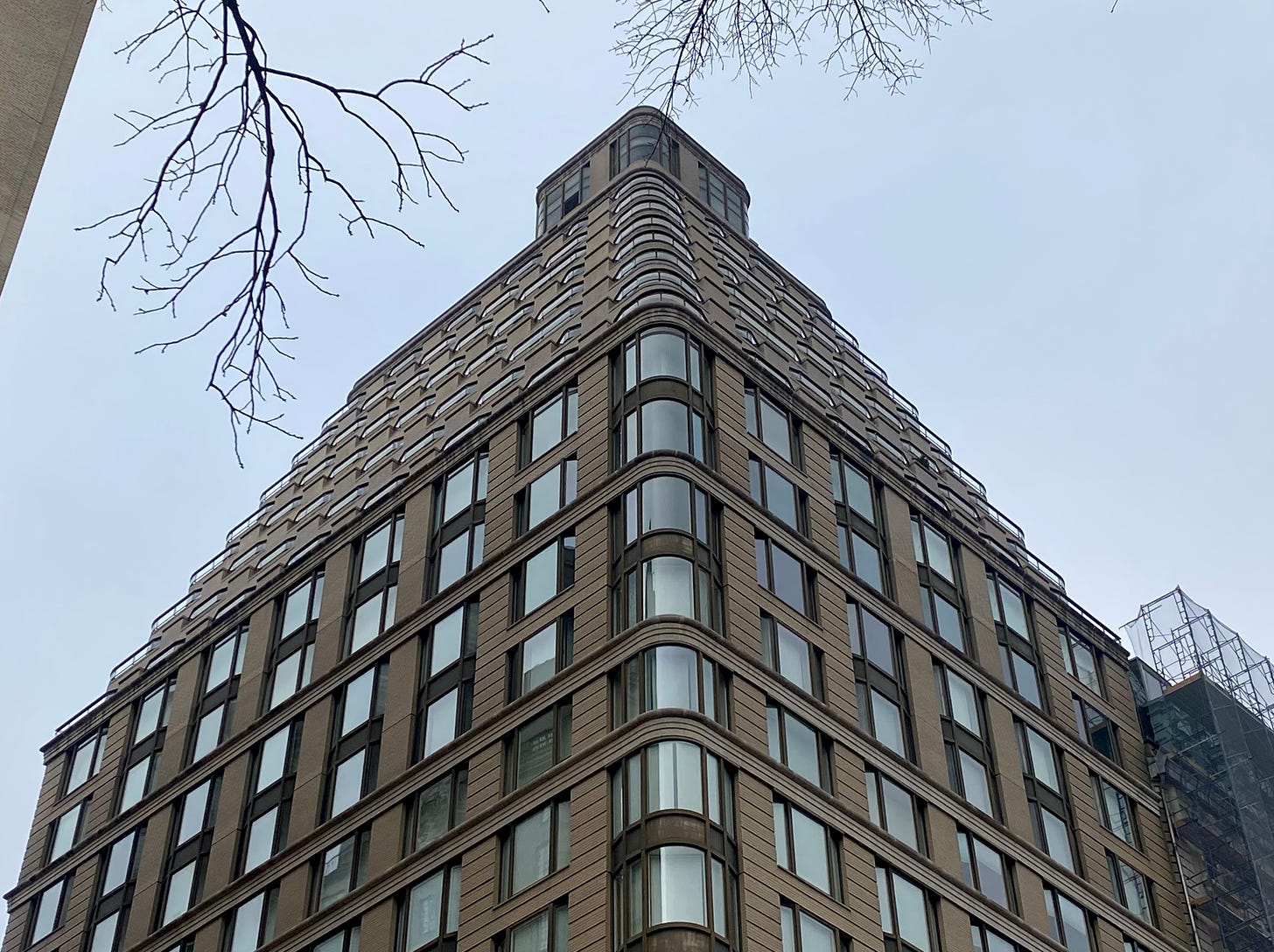 An upper west side apartment building with curved corners, stepping back to the roof.