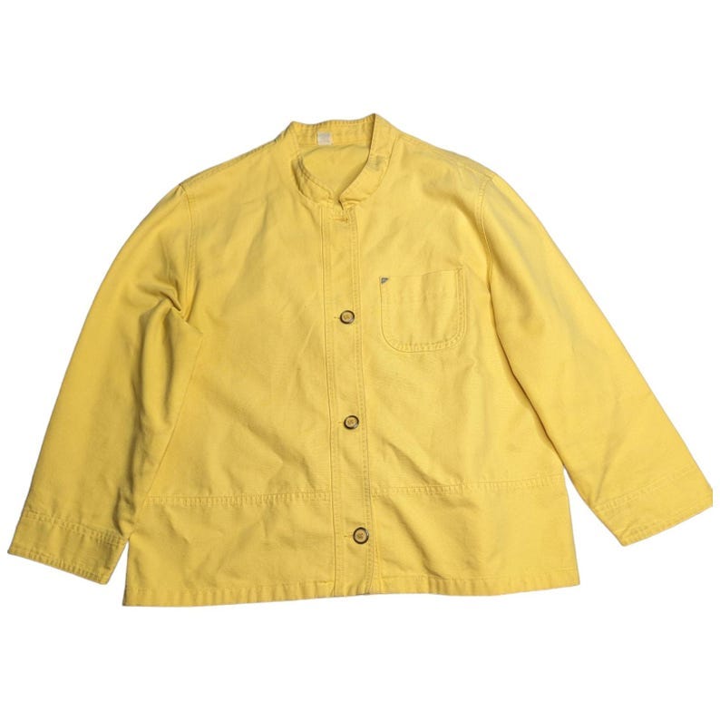 May include: A yellow button-up jacket with a mandarin collar and a single chest pocket.