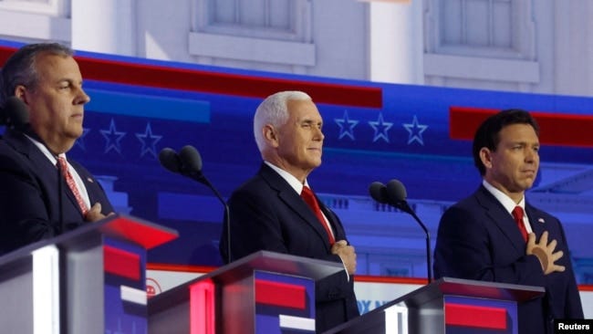 Former New Jersey Governor Chris Christie, former U.S. Vice President Mike Pence and Florida Governor Ron DeSantis hold their hands over their hearts for the U.S. Pledge of Allegiance at the start of at the first Republican candidates' debate of the 2024 U.S. presidential campaign in Milwaukee, Wisconsin.