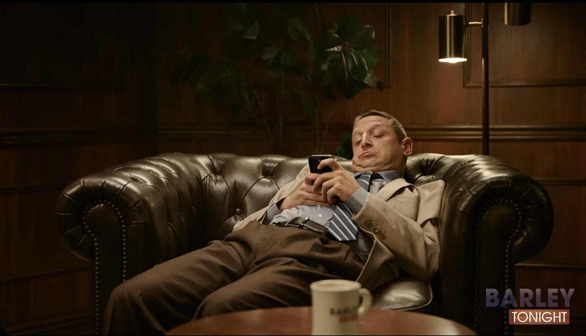 Tim Robinson in I Think You Should Leave's Barley Tonight sketch looking at his phone while sinking into a leather chair