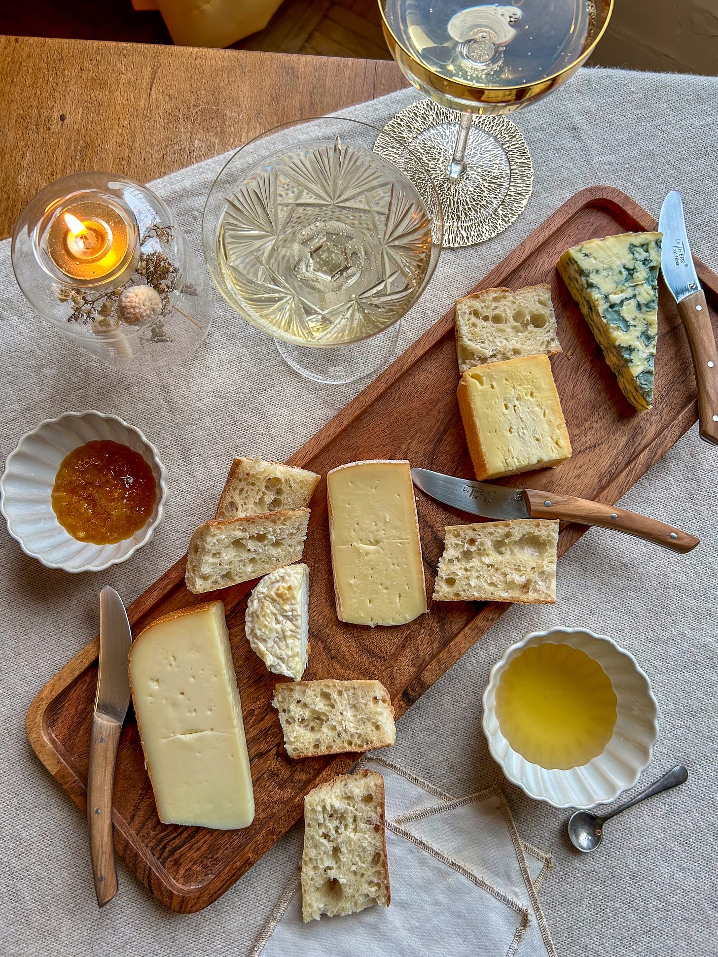Glasses of Champagne wait for guests at a party with a cheese platter and bread