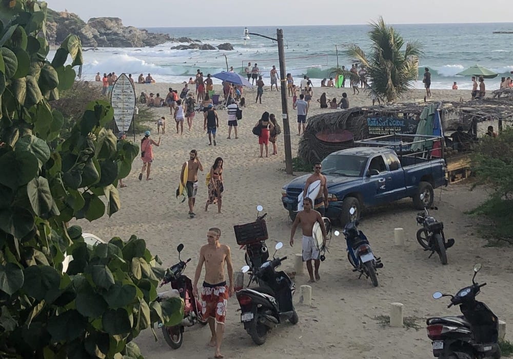 Beach with surfers in Puerto Escondido, Oaxaca representing a high vibe environment