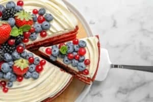 Delicious homemade red velvet cake with fresh berries on table, top view