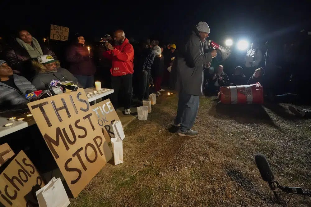 Rev. Andre E Johnson, of the Gifts of Life Ministries, preaches at a candlelight vigil for Tyre Nichols, who died after being beaten by Memphis police officers, in Memphis, Tenn., Thursday, Jan. 26, 2023. Behind him, seated at left, is Tyre's stepfather Rodney Wells. (AP Photo/Gerald Herbert)