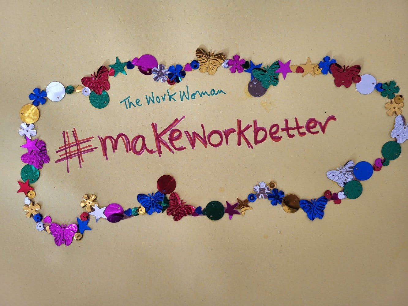 A squiggly sequin border surrounds the hashtag Make Work Better and above the hashtag are the words The Work Woman