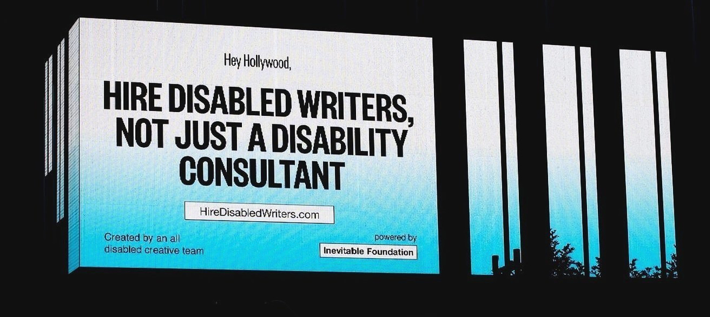 A digital billboard says “Hey Hollywood, HIRE DISABLED WRITERS, NOT JUST A DISABILITY CONSULTANT.”