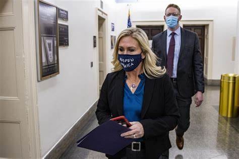 MTG walks through congress with a cloth mask that says "Reopen America"