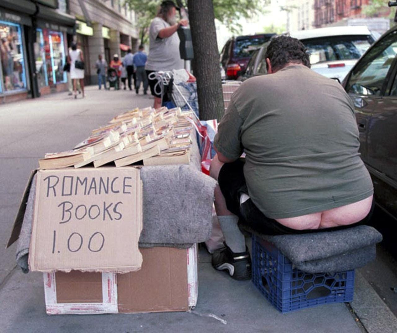 A street book vendor on the Upper West Side gets engrossed in one of his own books for sale.
