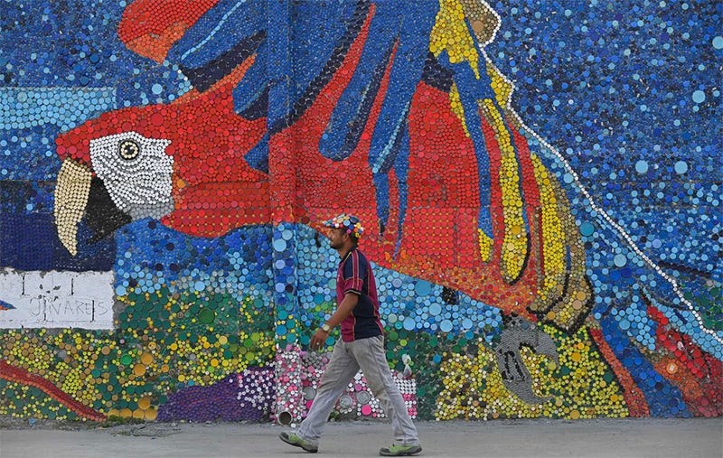 Mosaic of a parrot with a man walking in front of it